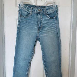 high waisted blue washed american eagle skinny jeans, with distressed ankles
